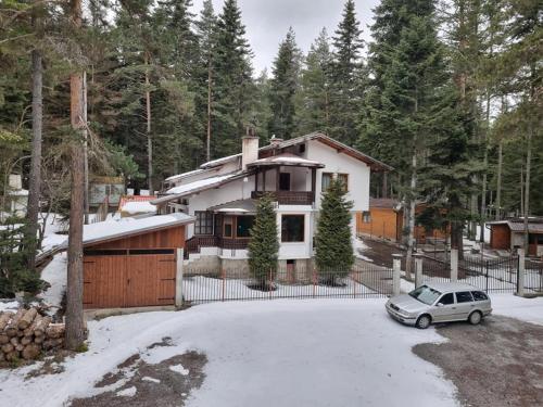 a car parked in front of a house in the snow at Вила Пенчеви, кк. Цигов чарк in Tsigov Chark