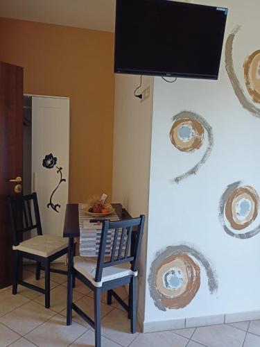 a dining room with a table and chairs and a television at Il Faggio 17 B&B in Artena