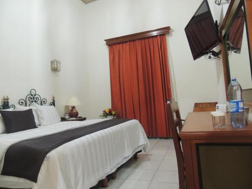 a bedroom with a bed and a red curtain at Hotel Concierge Plaza Colima in Colima
