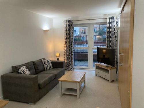 a living room with a couch and a tv at Apartment D102 in Kingsthorpe