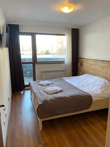 a bedroom with a bed with two towels on it at Belvedere luxury apartment in Bansko