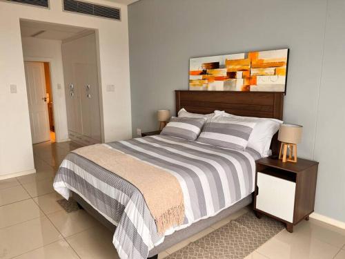 a bedroom with a bed and a painting on the wall at iTowers luxurious 1-Bedroom apartment- 15th Floor in Gaborone