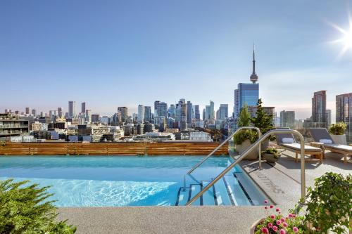 トロントにある1 Hotel Torontoの市街のスカイラインを背景にしたスイミングプール