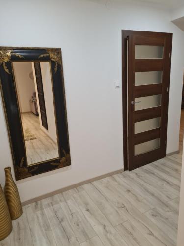 a mirror on a wall next to a door at Pod Świerkami in Myślibórz