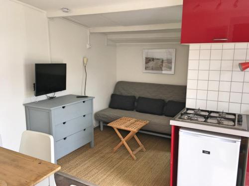 een kleine woonkamer met een bank en een keuken bij Vacances Sur Mer in Saint-Palais-sur-Mer