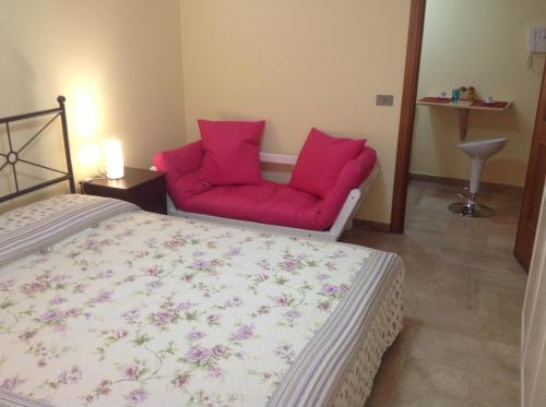 a bedroom with a bed and a red couch at Residence Le Lumie in Trapani