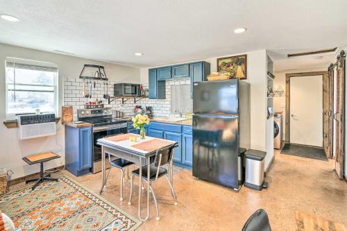 a kitchen with blue cabinets and a table and a refrigerator at Kid-Friendly House about 8 Mi to Cedar Rapids! in Cedar Rapids