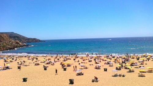 a large group of people on a beach at Perfect Location, Idyllic 2BR Apartment in Sliema
