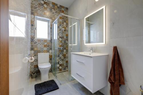 ein Bad mit einem WC, einem Waschbecken und einer Dusche in der Unterkunft Perfect Location, Modern 2BR Apartment in Sliema