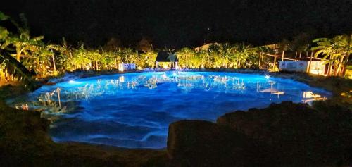a large pool of blue water at night at Coco Resort & Villas in Motul de Felipe Carrillo Puerto