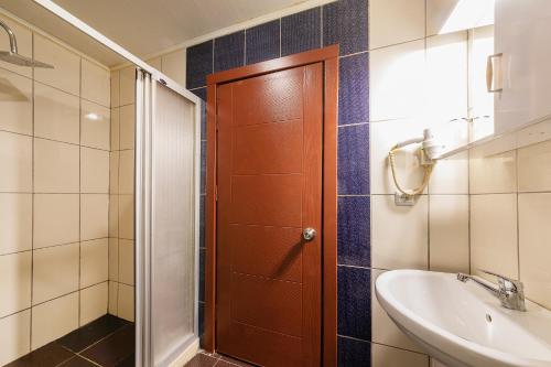 a bathroom with a shower and a sink and a door at Vefa Hotel&Suites in Istanbul