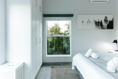 a white bedroom with a bed and a window at Kingswood Manor No.17 in George