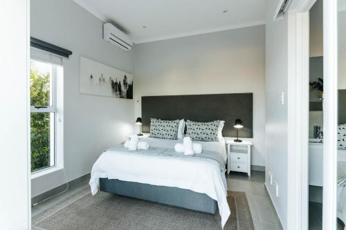 a white bedroom with a large bed and a window at Kingswood Manor No.17 in George