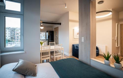 a bedroom with a bed and a dining room at Apartamenty ZOFIJÓWKA in Toruń