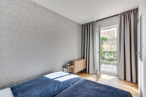 1 dormitorio con cama y ventana grande en Apartament Mechelinki en Mechelinki