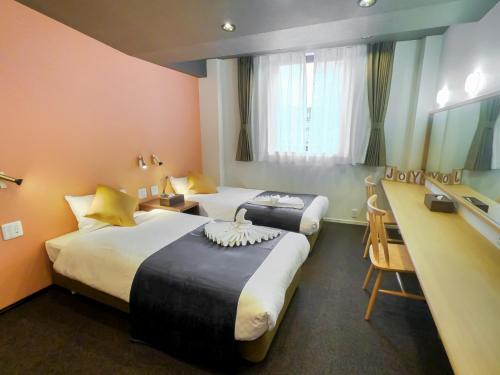 a hotel room with two beds and a mirror at Hotel S-Presso Central - Vacation STAY 9444 in Osaka