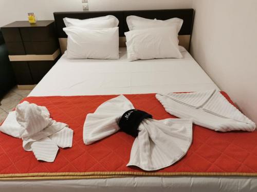 a bed with white clothes and a bow tie on it at Studios Nelli Alonissos in Patitiri