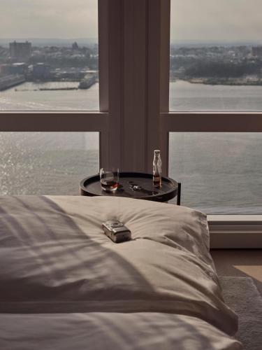 a bedroom with a bed and a table with two glasses at Equinox Hotel New York in New York
