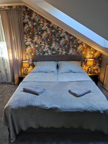 a bedroom with a large bed with a floral wall at Pensjonat Klimat Bircza in Bircza