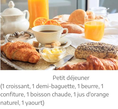 - une table de petit-déjeuner avec des viennoiseries, du café et de l'orange jus dans l'établissement Les Alizés, à Holtzwihr