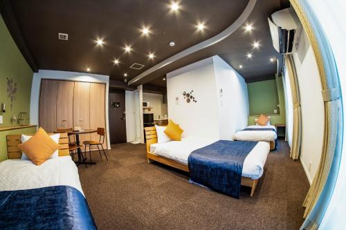 a hotel room with two beds and a table at Hotel S-Presso Central - Vacation STAY 9451 in Osaka