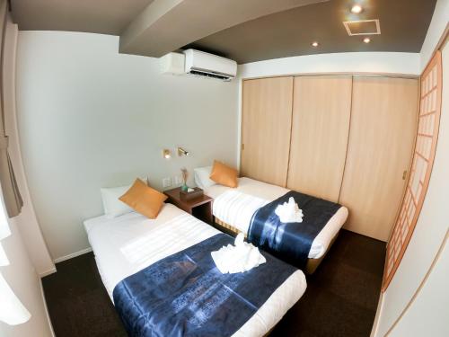 een kamer met 2 bedden in een kamer met bij Hotel S-Presso Central - Vacation STAY 9445 in Osaka