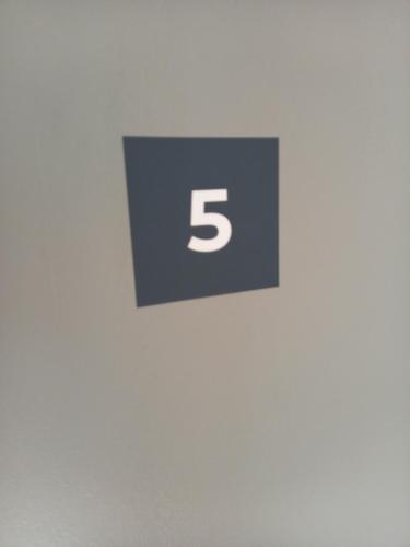 a sign with the number five on a wall at chambres et gites d'étretat in Étretat