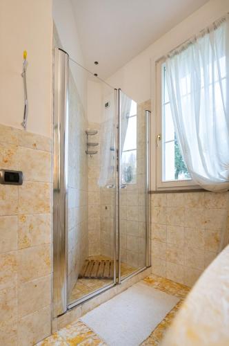 a shower with a glass door in a bathroom at B&B LA VILLA in Forlì