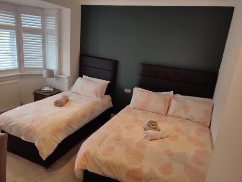 a bedroom with two beds with towels on them at Apple House Wembley in Barnet