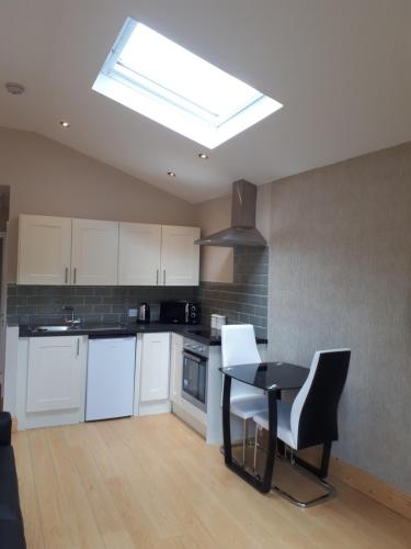 a kitchen with a table and chairs and a skylight at One double bedroom flat in Dublin