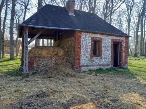 a small brick house with a roof on a field at chambres et gites d'étretat in Étretat