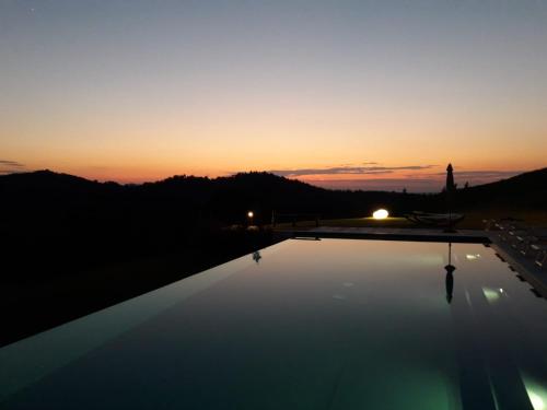 a view of the sunset from a swimming pool at Il Pavone Errante in Ciola