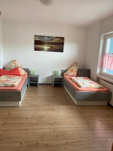 a room with two beds and two tables at FEWO Schmandin Laacher See in Wassenach