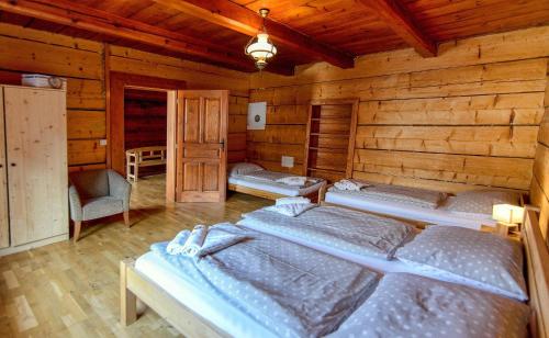 a bedroom with three beds in a wooden cabin at Chalupa Tomas Ždiar in Ždiar
