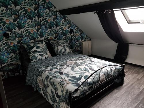 1 dormitorio con 1 cama y papel pintado con motivos florales en Cosy Lodg, en Bourogne