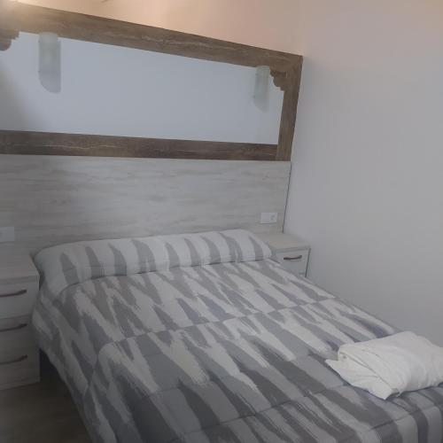 1 dormitorio con 1 cama con edredón a rayas y ventana en Apartamento el cuco, en Aldeanueva de la Vera