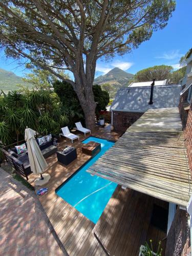 une cour arrière avec une piscine et une terrasse en bois dans l'établissement Cosy and Unique Family Retreat in Hout Bay, au Cap