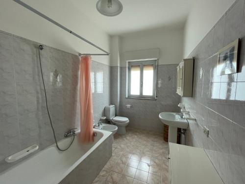 a bathroom with a tub and a toilet and a sink at Pipa’s SunTrap in Taormina