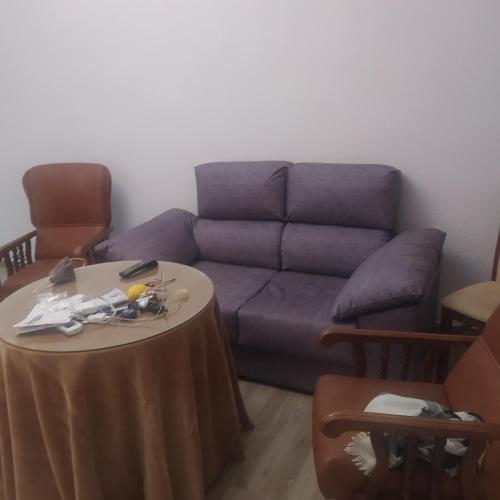sala de estar con sofá púrpura y mesa en Apartamento el cuco, en Aldeanueva de la Vera