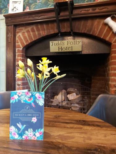 a vase of flowers on a table in front of a fireplace at The Judds Folly Hotel, Sure Hotel Collection by Best Western in Faversham