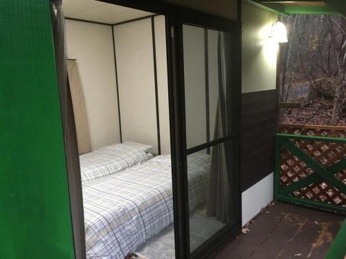 1 dormitorio con 1 cama en una habitación con espejo en SEE-GOT-LIKE-Sansou - Vacation STAY 87979v en Tsumagoi