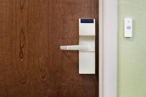 a wooden door with a white handle on it at Holiday Inn Express & Suites Philadelphia - Mt Laurel by IHG in Mount Laurel