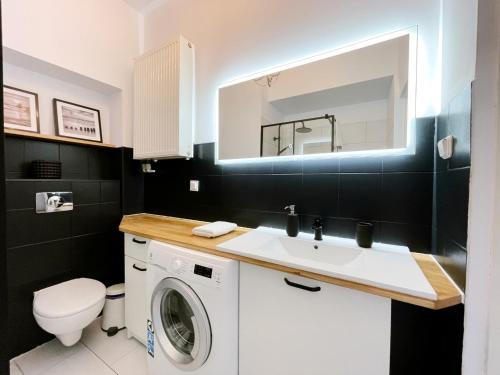 y baño con lavabo y lavadora. en Comfy Apartments - Centrum Monte Cassino en Sopot