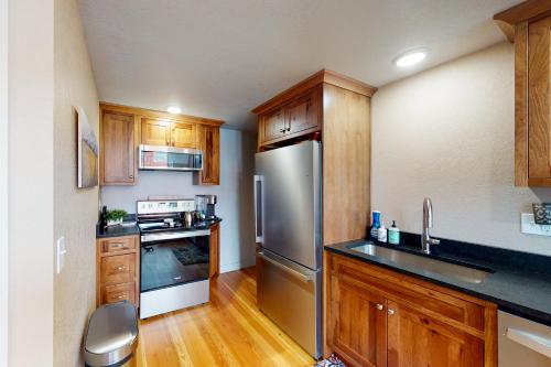 a kitchen with wooden cabinets and a stainless steel refrigerator at The Loft Downtown in Joseph