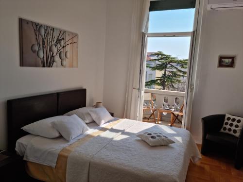a bedroom with a bed and a large window at Rooms Tisa Old Town in Zadar
