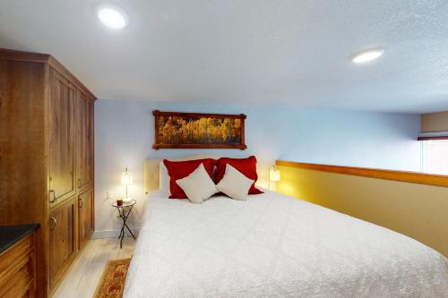 a bedroom with a large white bed with red pillows at The Loft Downtown in Joseph