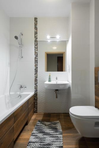 a bathroom with a sink and a tub and a toilet at Apartamenty Maestro in Gdynia