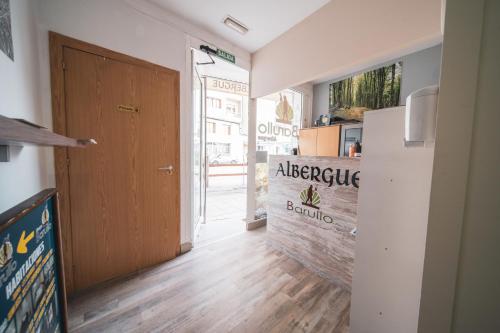 a hallway with a door and a refrigerator in a room at Albergue Barullo - Cubículos - Literas - Habitaciones in Sarria