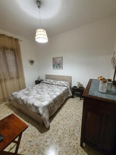 Un dormitorio con una cama y una mesa. en Casa Papona en Sezze
