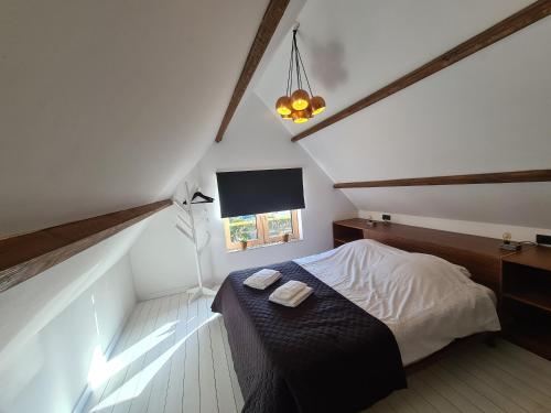 a attic bedroom with a bed and a window at Studio12A in Domburg